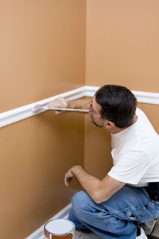 Painter painting wall trim