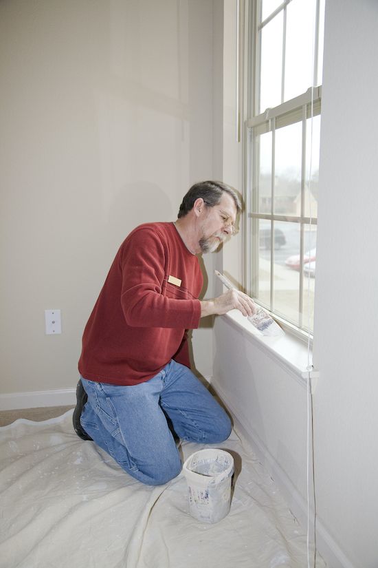 Painter painting window and trim