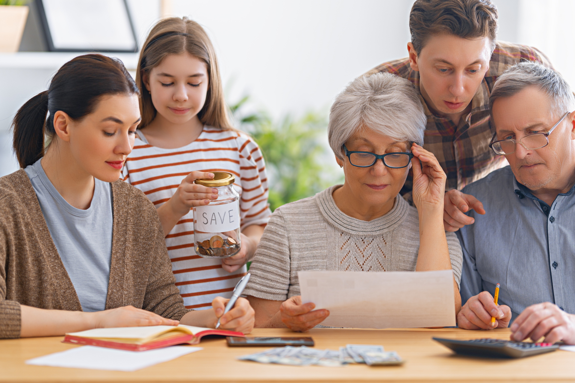 Family gathered around a table, reviewing financial documents with concern.