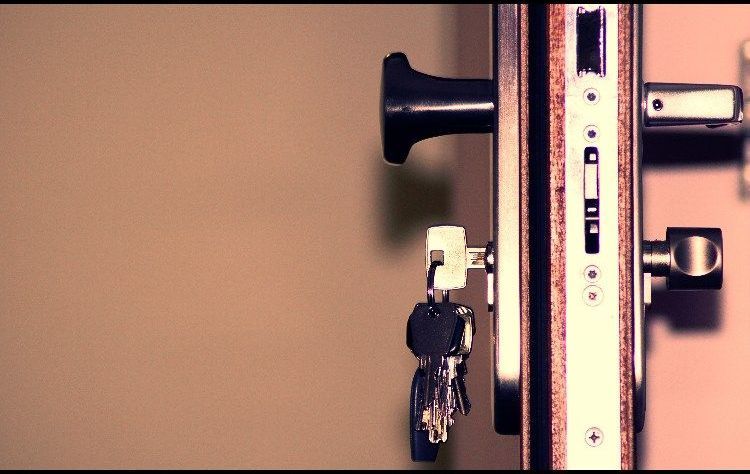 A close up of a door lock with keys in it