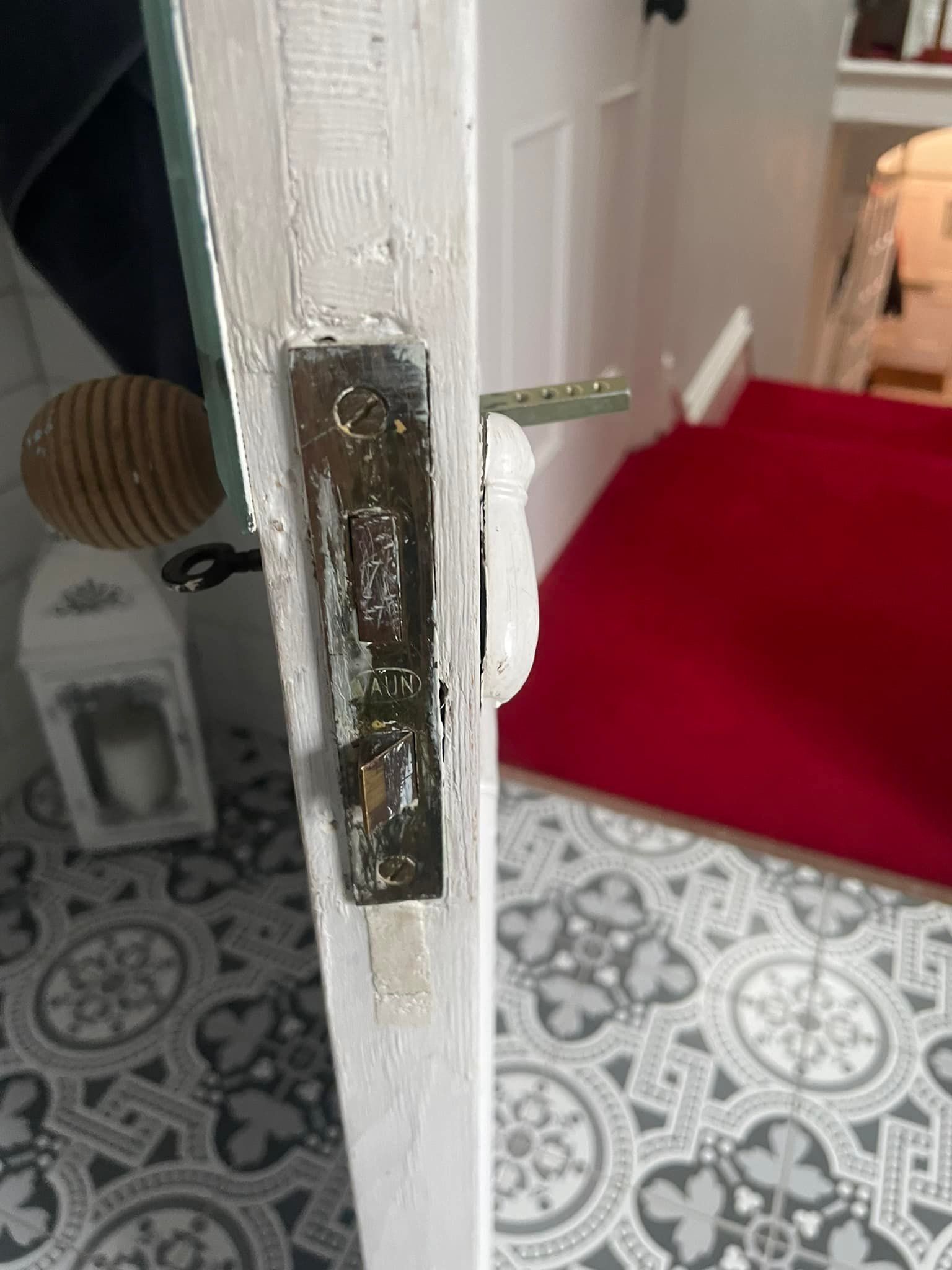 A close up of a door with a broken handle in a room.