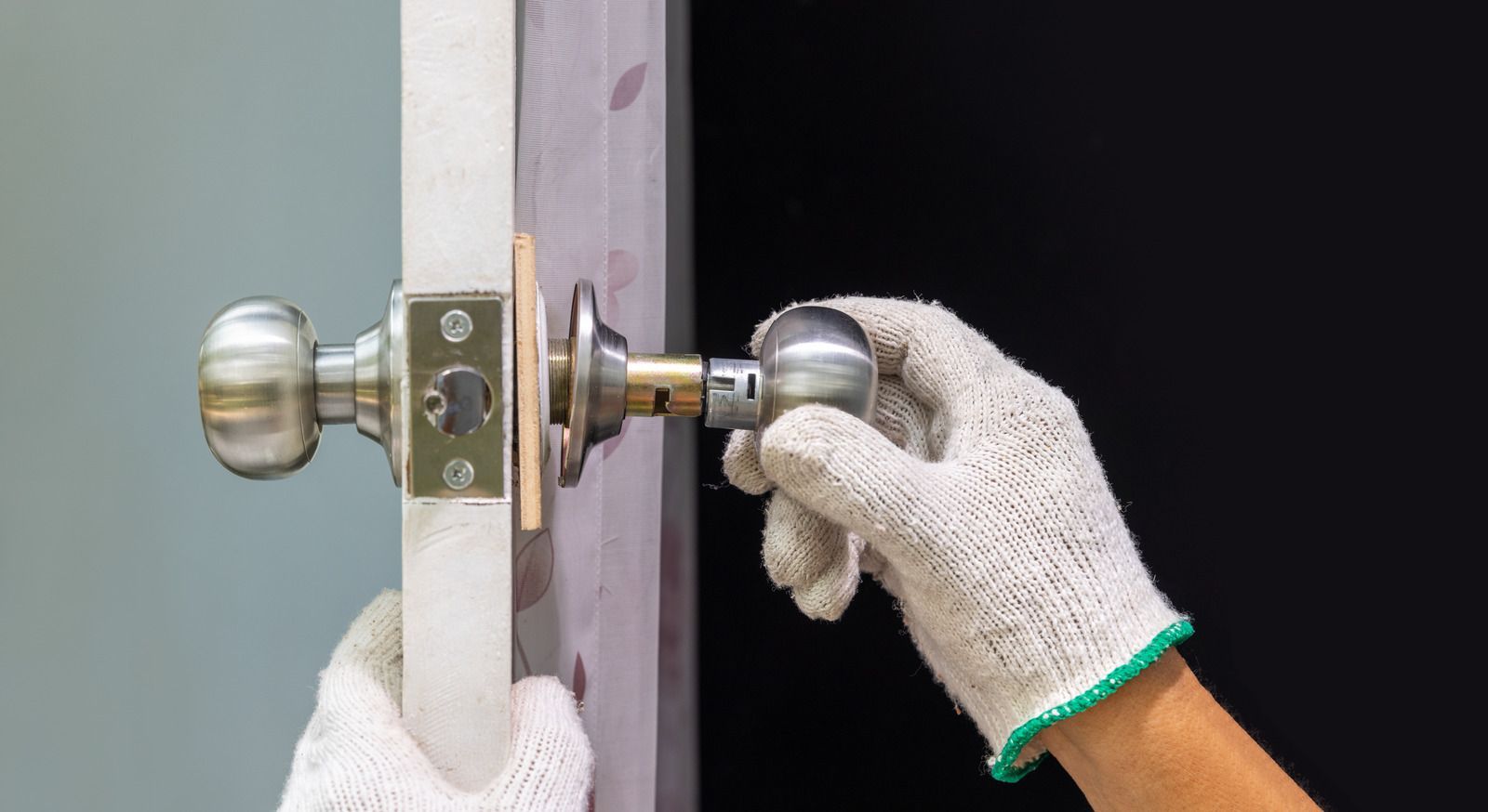 A person is installing a door knob on a door.