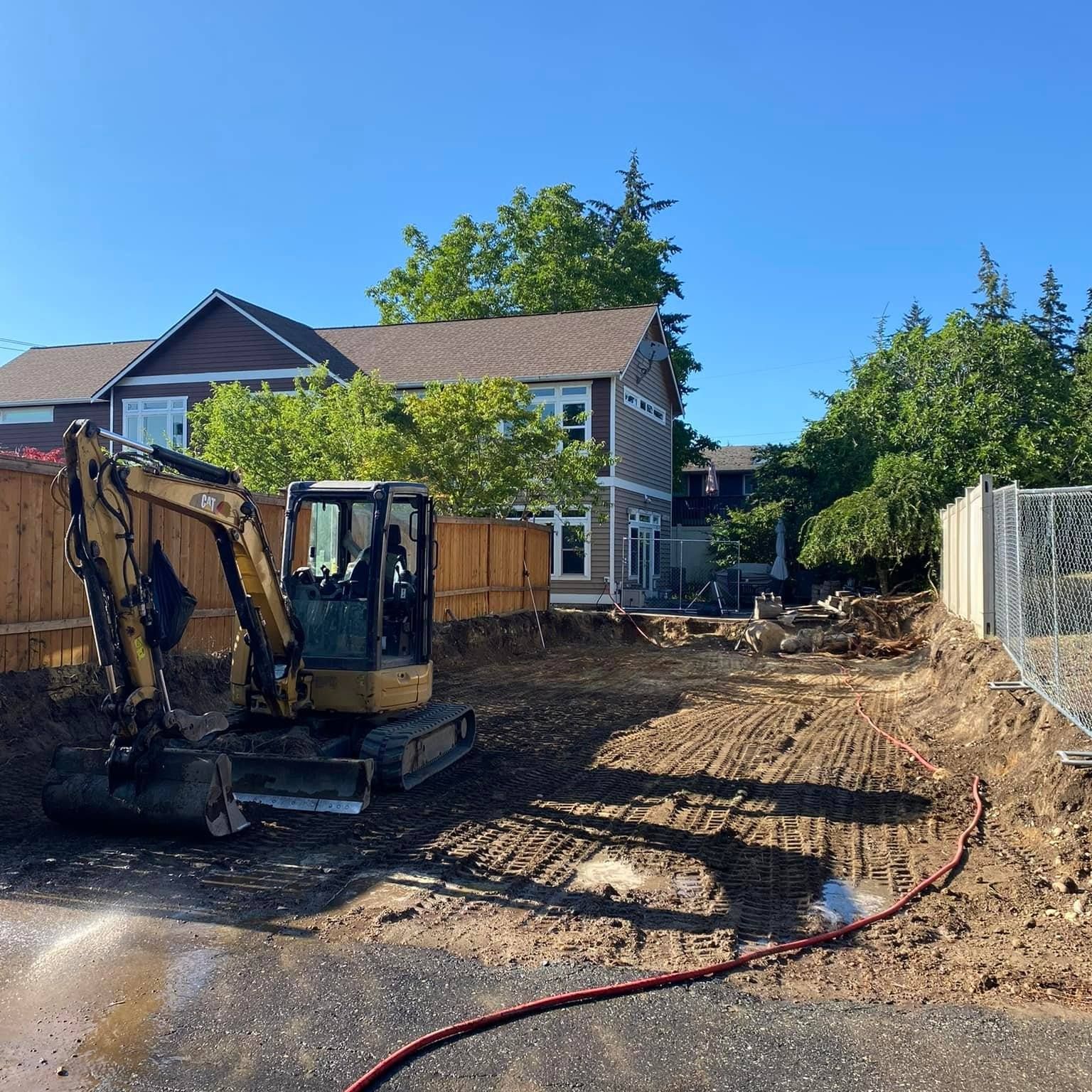 A bulldozer is loading dirt into a dump truck at a construction site.