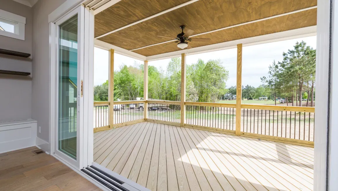 A screened in porch with sliding glass doors and a ceiling fan.