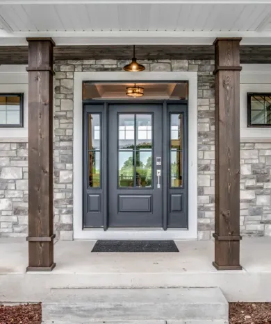 The front door of a house with a brick wall and a black door