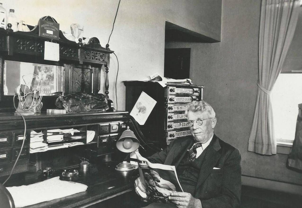 Photo of founder Thomas Harrison seated at his desk at the Harrison Funeral Home in Kewanna around 1945.