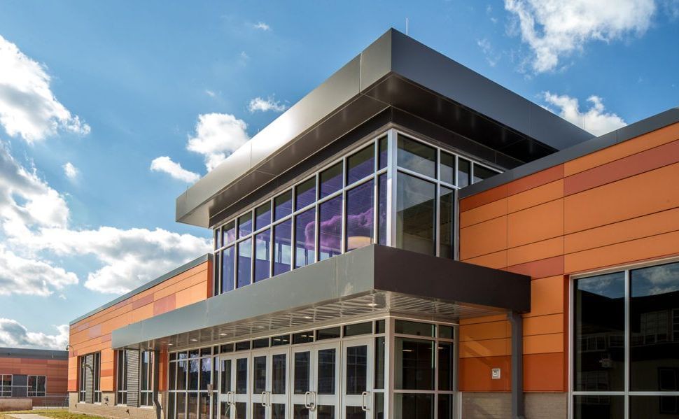 A large building with a lot of windows and a blue sky in the background.