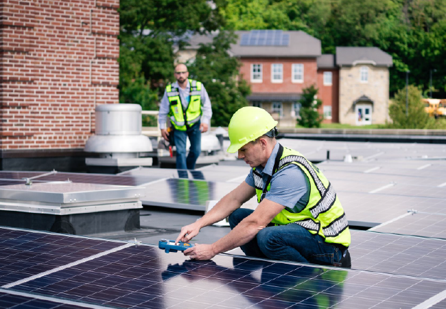 A man is installing solar panels on the roof of a building.