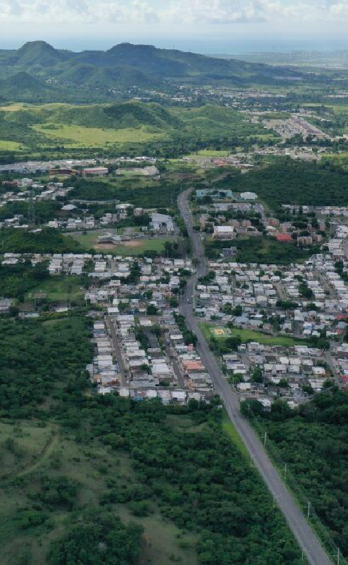 An aerial view of a city surrounded by trees and mountains.