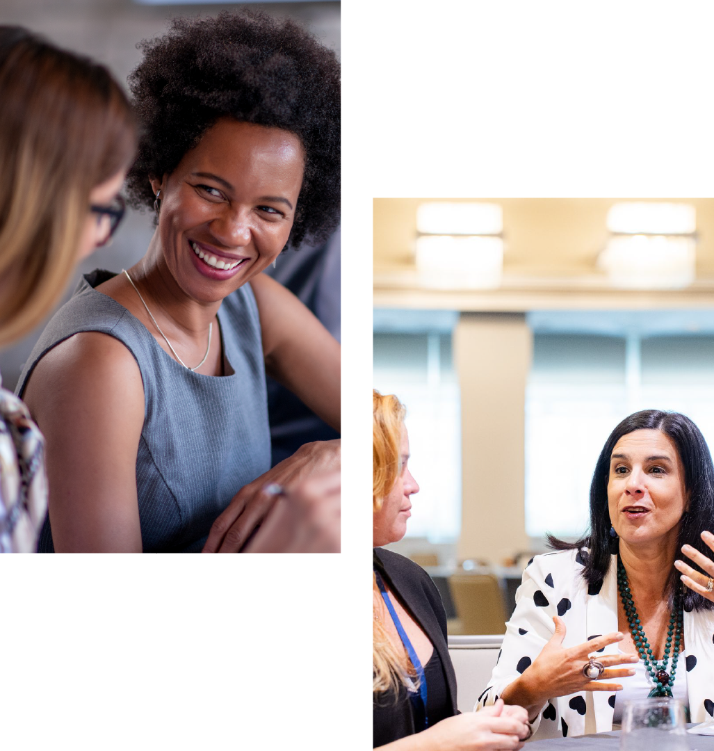 A woman is smiling while talking to two other women