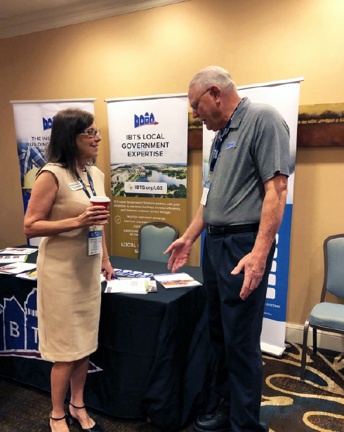 A man and a woman are standing next to each other at a table