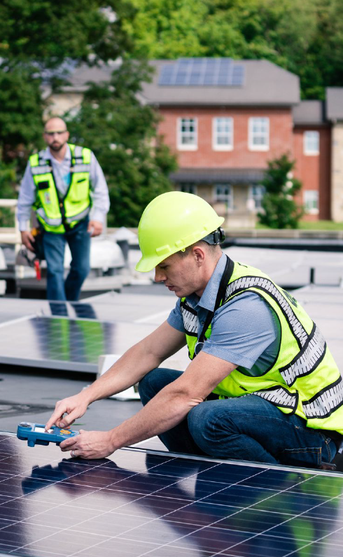 Two men are installing solar panels on a roof.