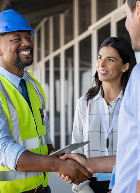 A man in a hard hat is shaking hands with a director