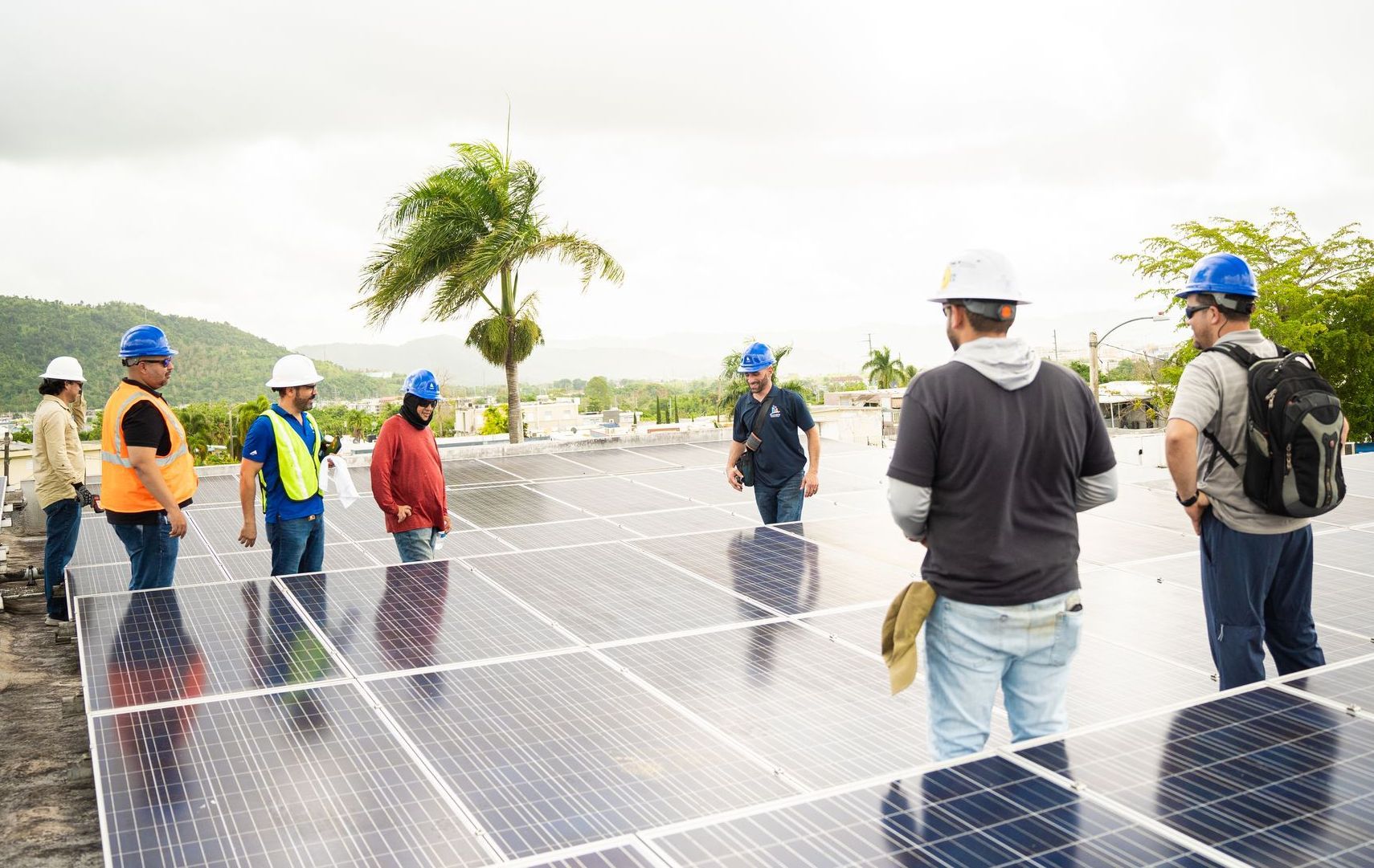 A group of people are standing on top of a solar panel.