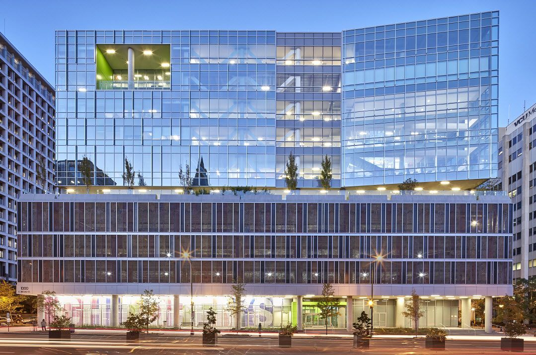 A large building with a lot of windows and a green roof.