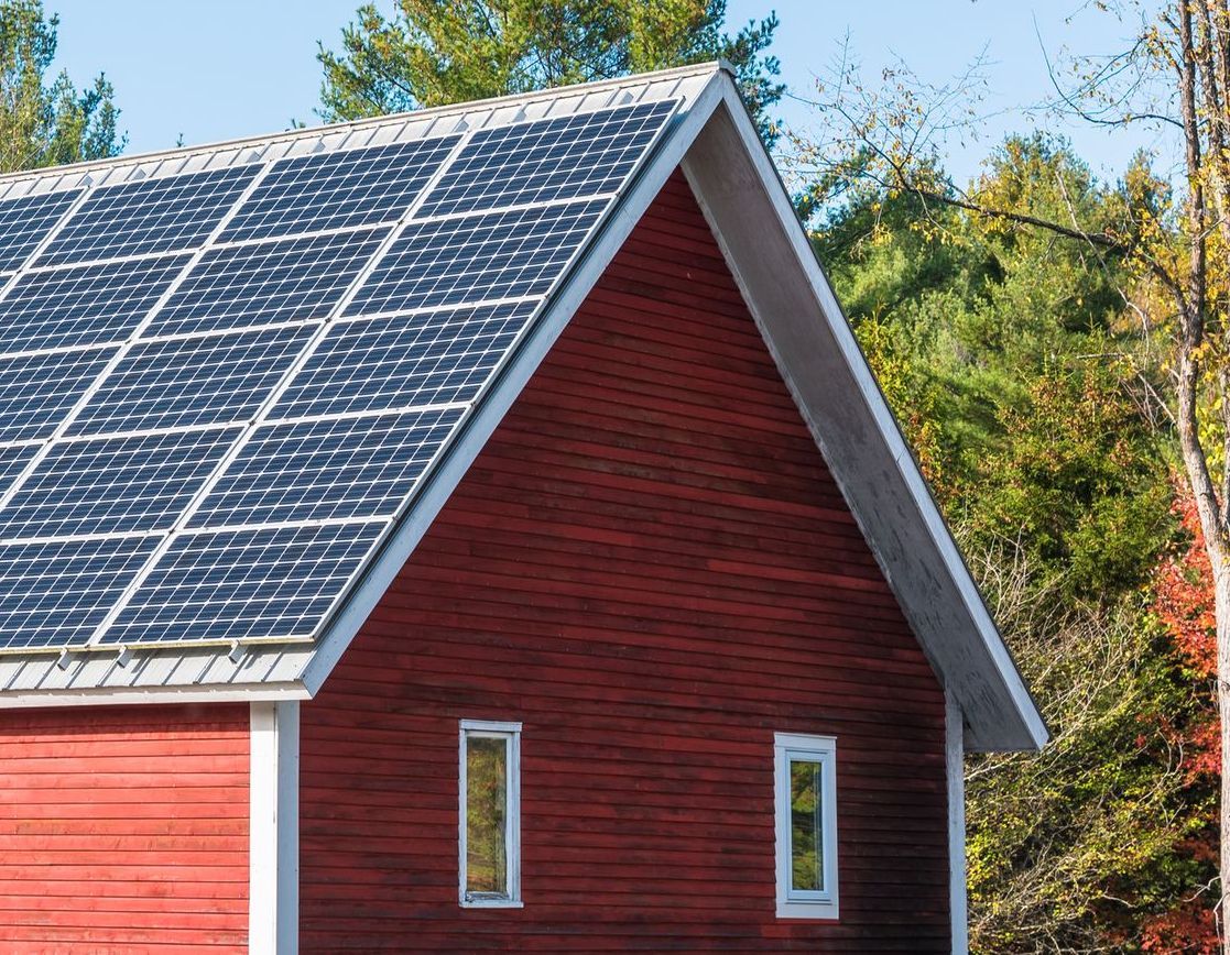 A red barn with solar panels on the roof