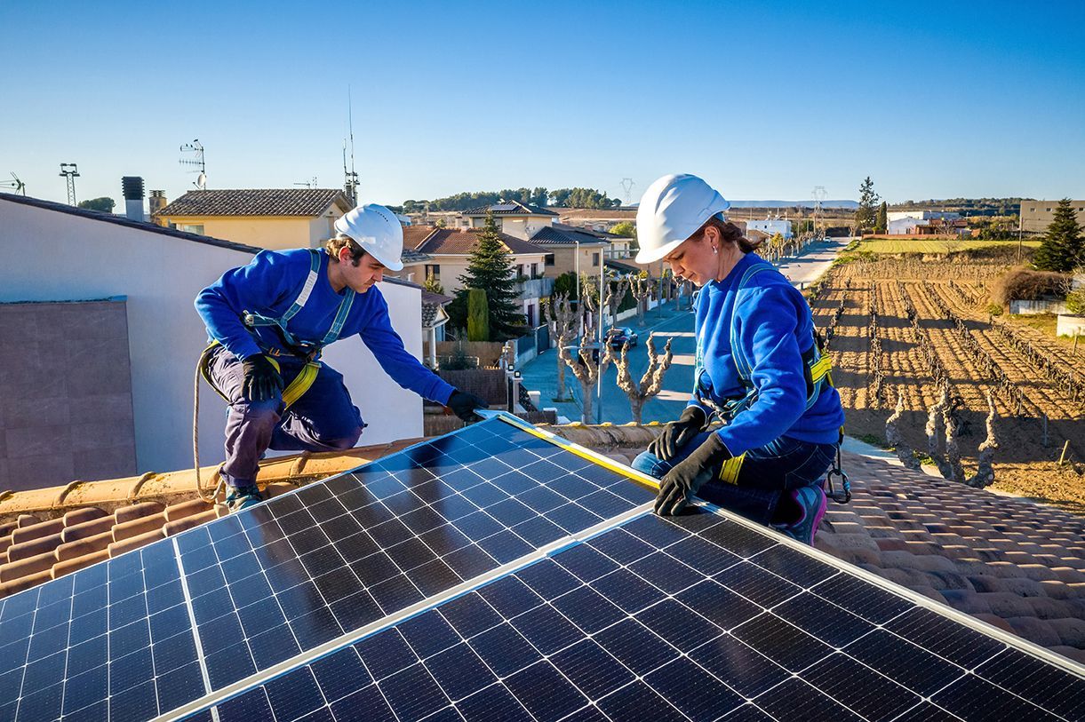 Two solar specialists measuring solar panels installation on a roof.