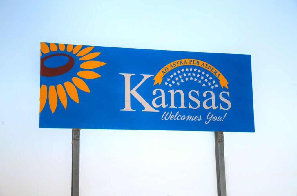 A blue sign that says kansas welcomes you