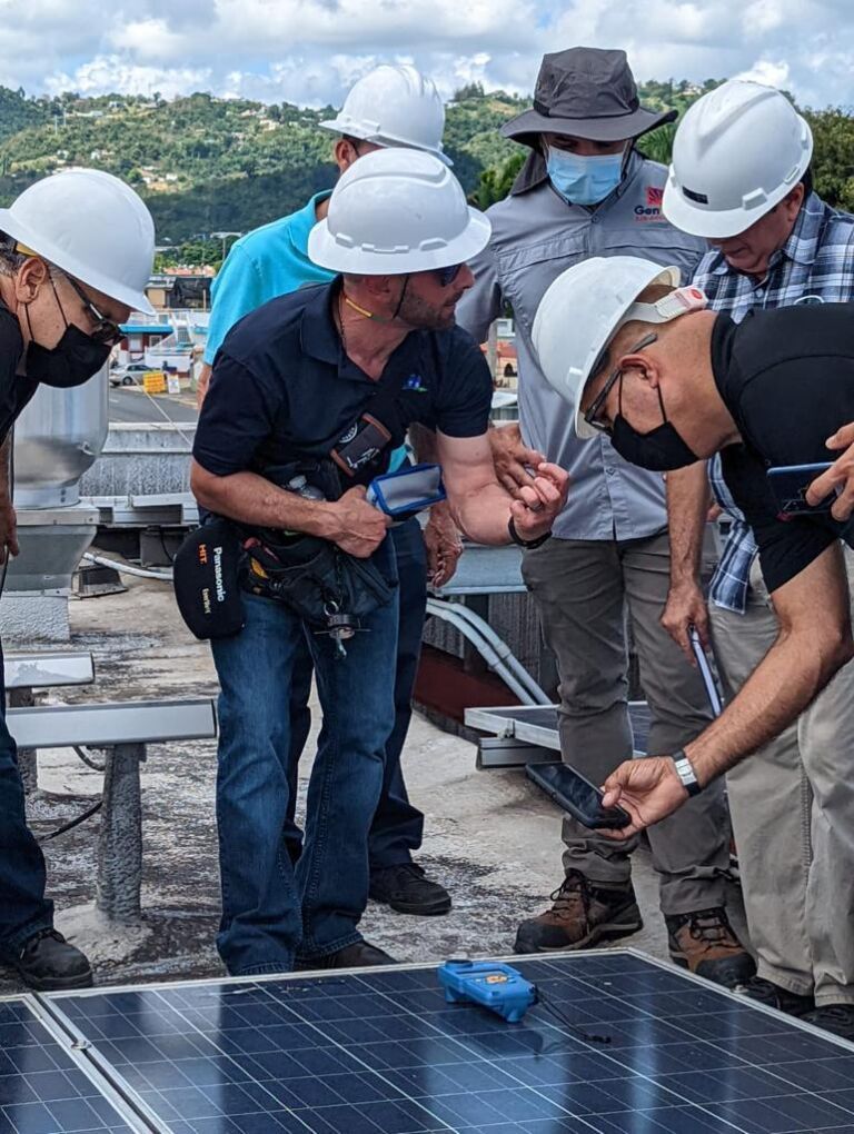 A group of men wearing hard hats and masks are working on a solar panel.