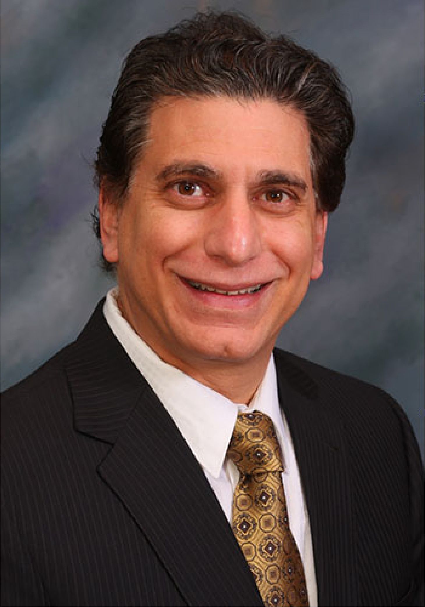 A man is holding a dog in his arms and the dog is wearing a sweater.