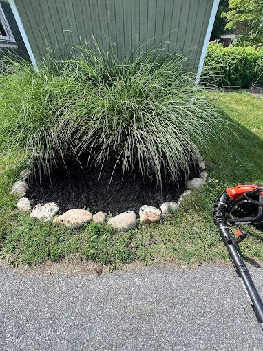 A lawn mower is sitting next to a bush in a garden.