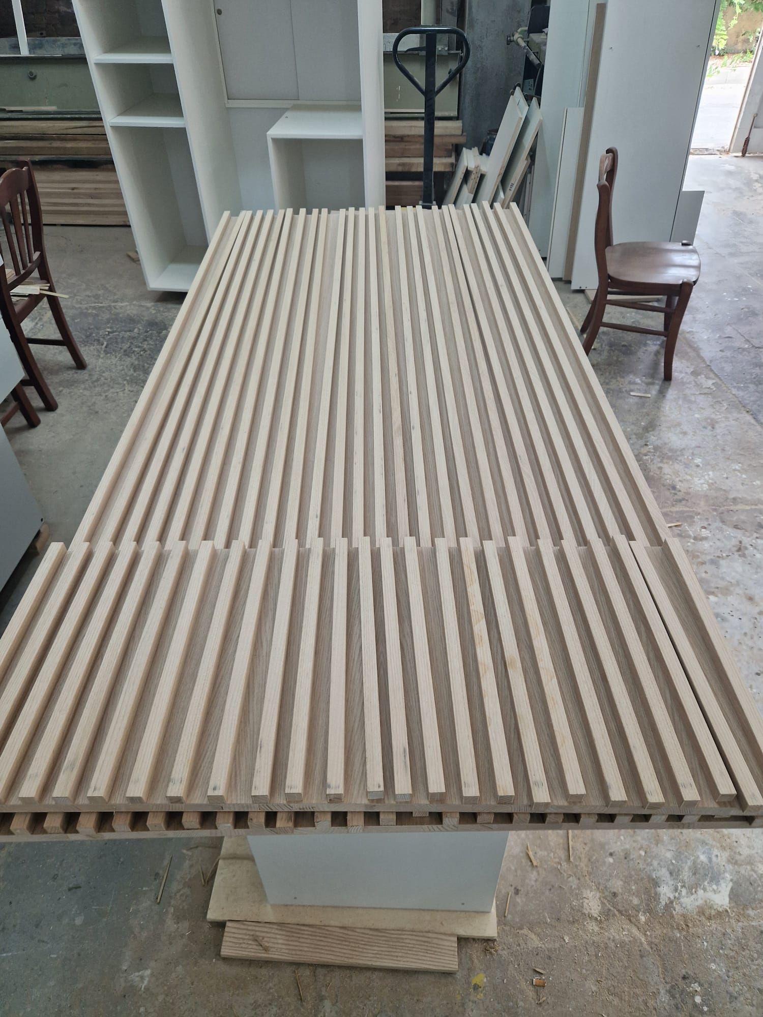 In una stanza c'è un tavolo di legno appoggiato su un pavimento di cemento.