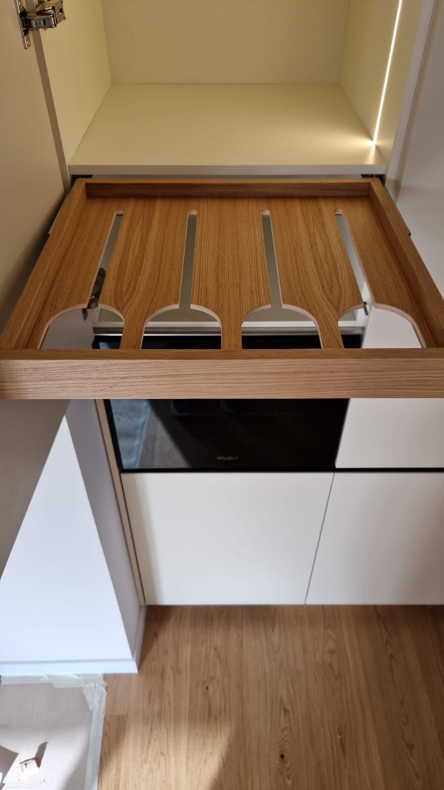 Un vassoio di legno con sopra degli utensili in una cucina.