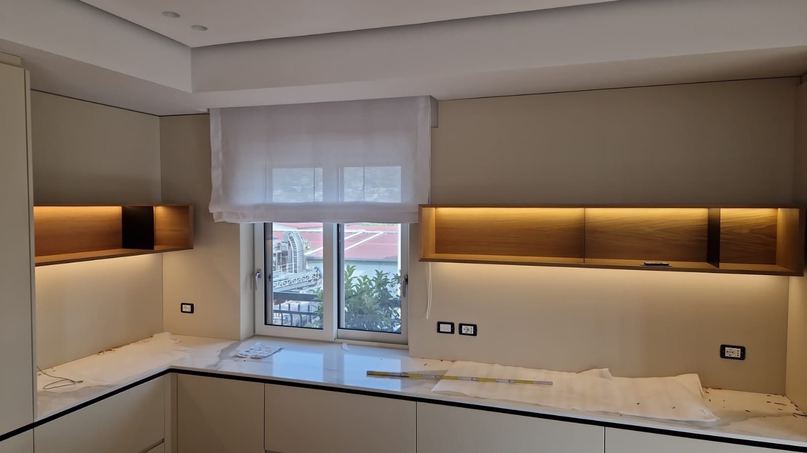 Una cucina con mobili bianchi e una finestra.