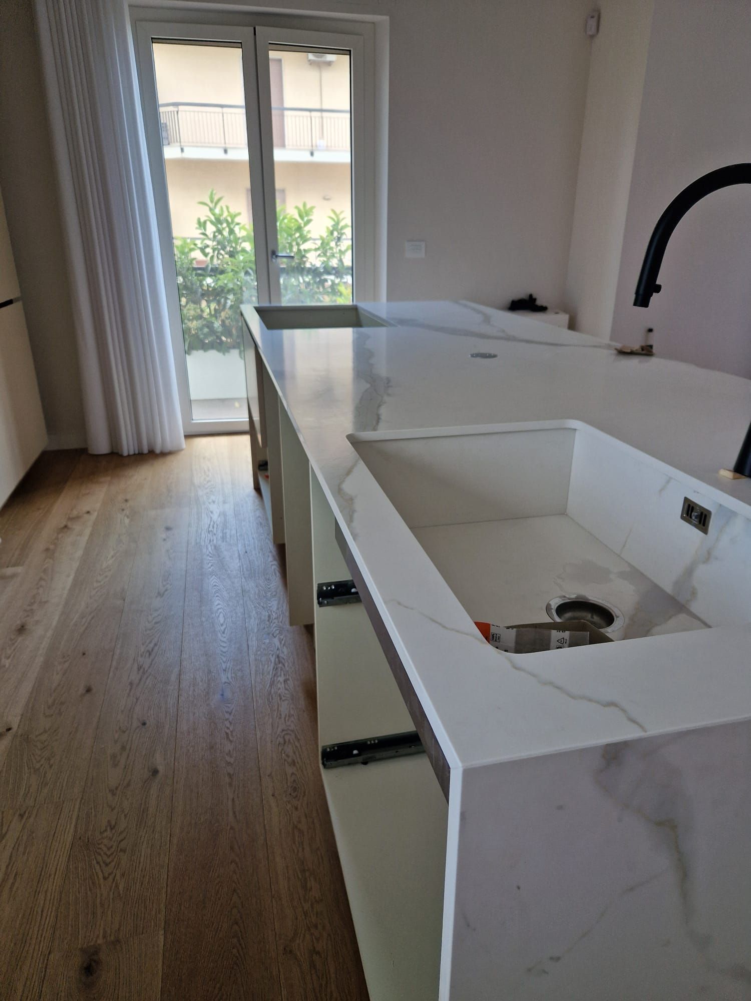 Una cucina con un grande lavello e una grande finestra.