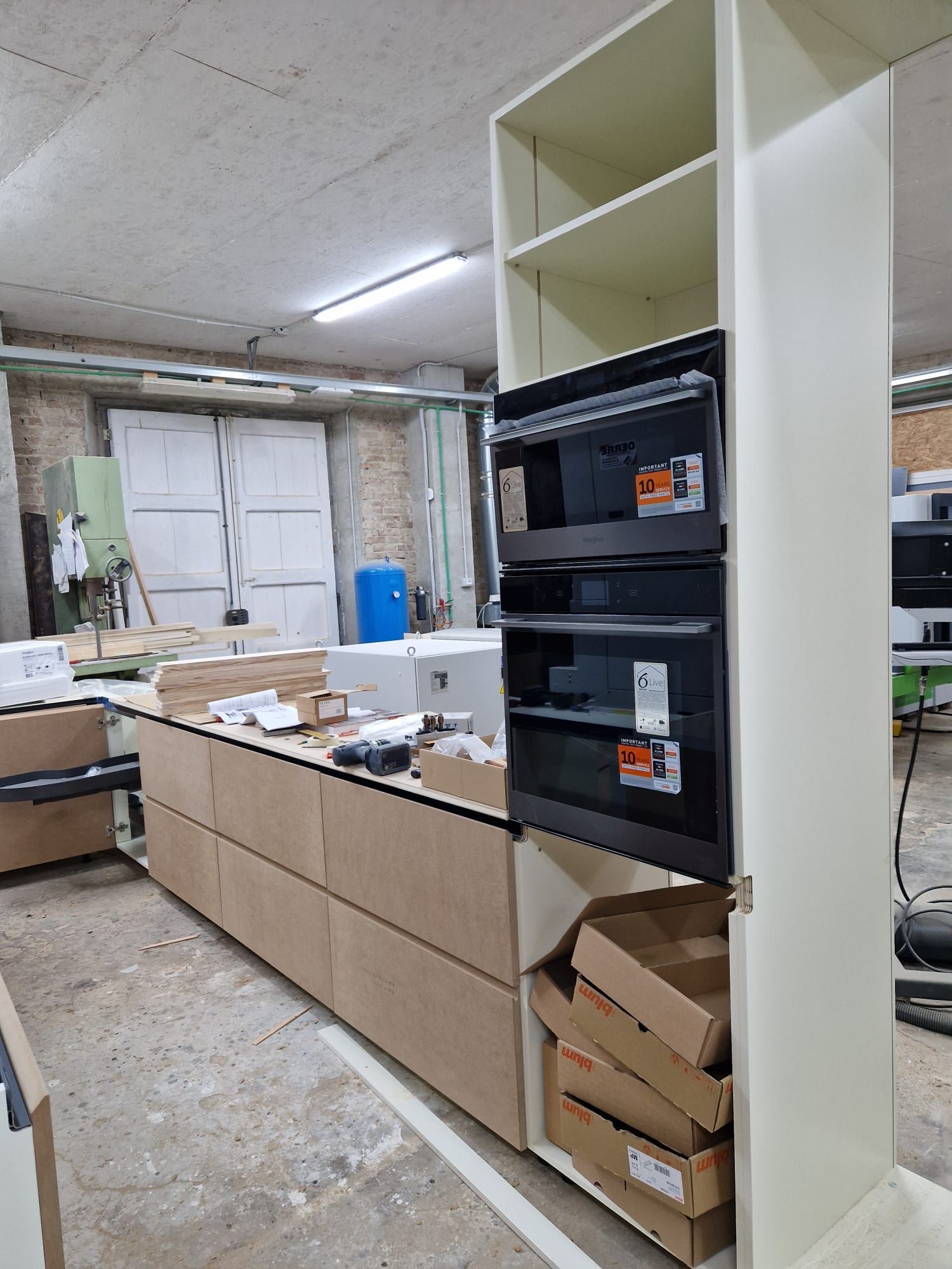 Una cucina con mobili in legno, cassetti e un forno a microonde.