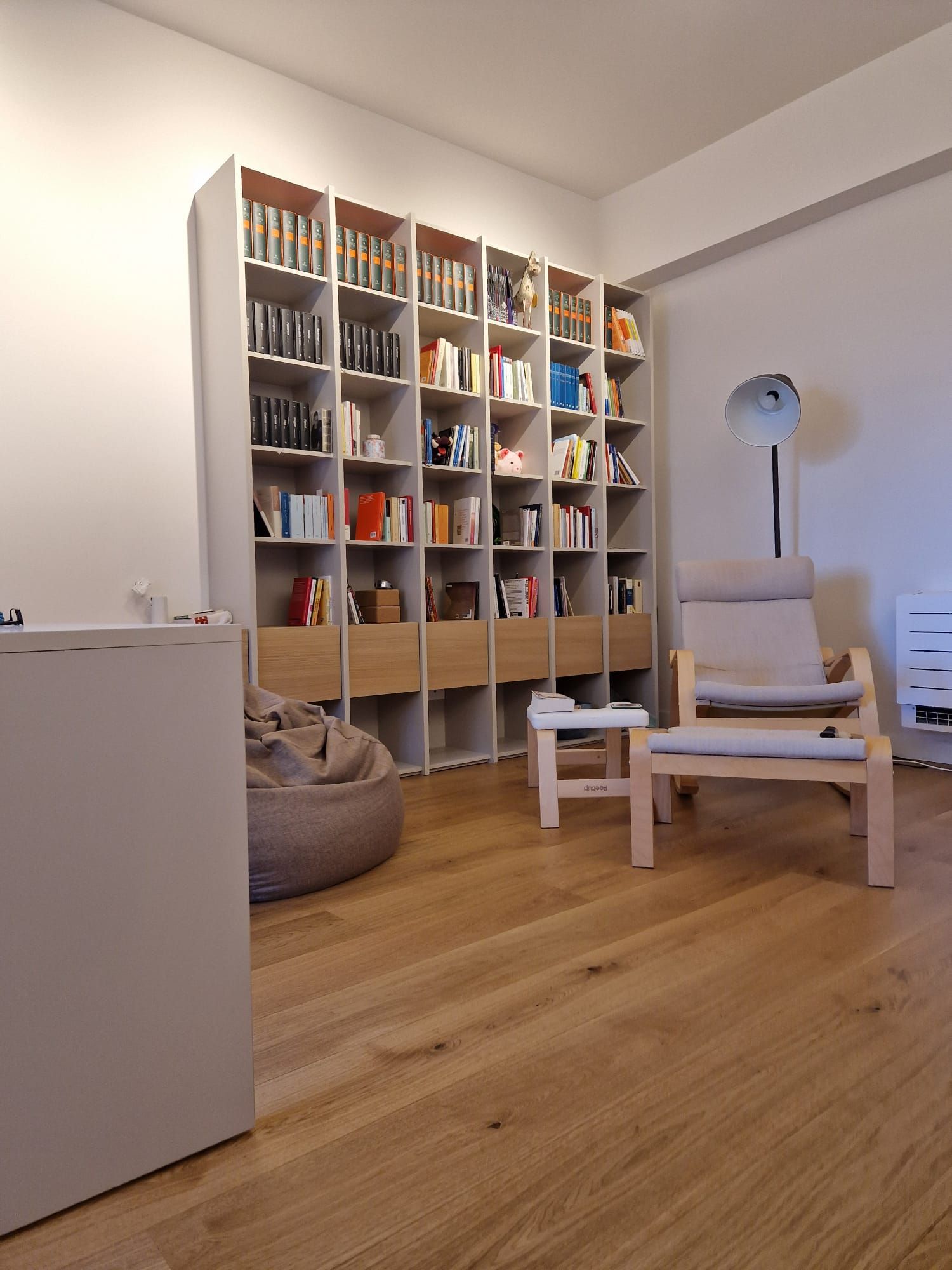 Un soggiorno con tante librerie e sedie