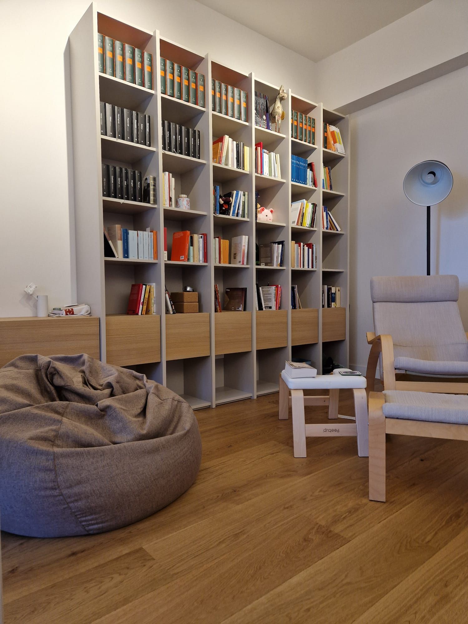 Un soggiorno con tante librerie e una poltrona a sacco