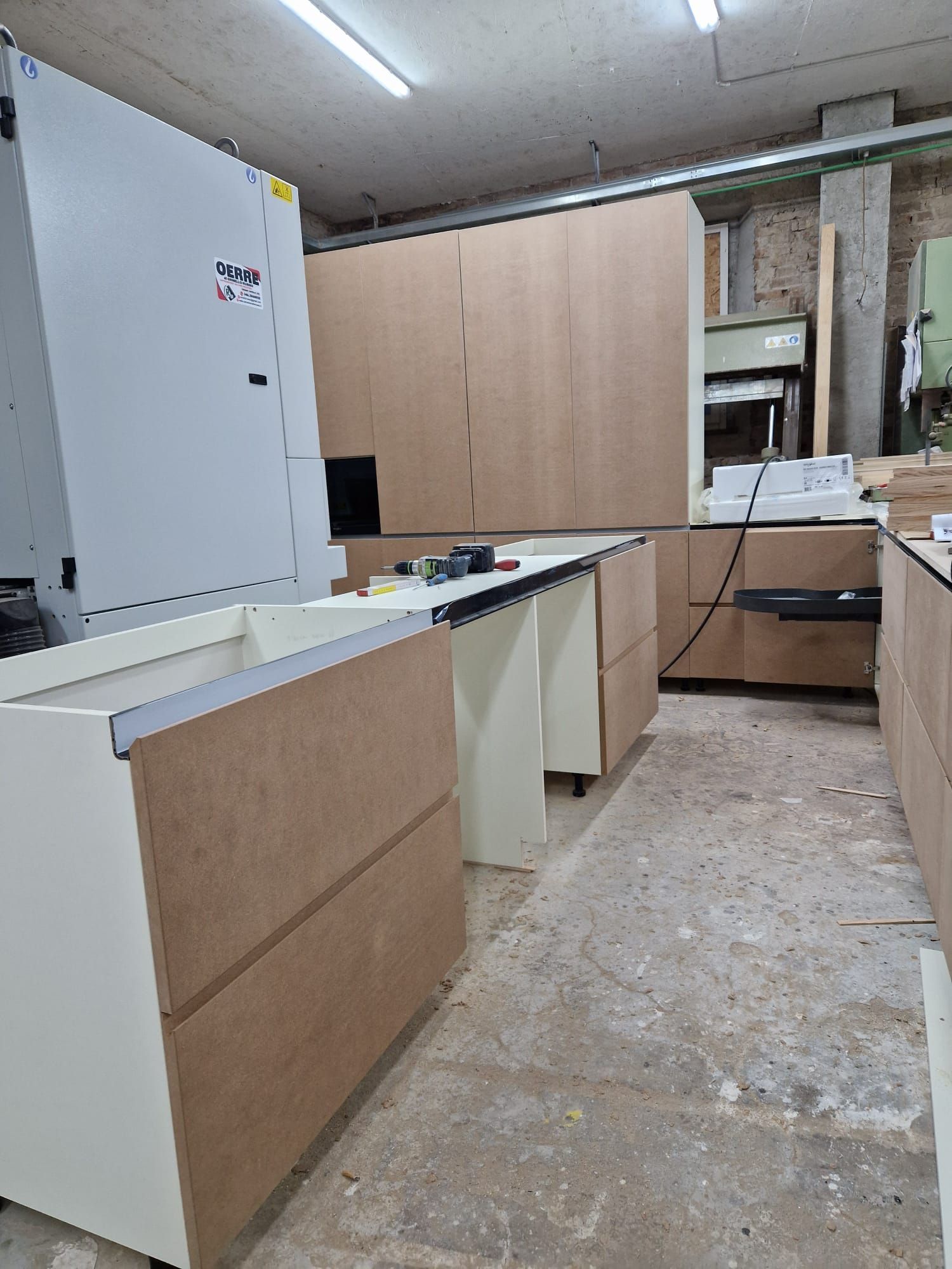 Una cucina con mobili in legno e un piano di lavoro bianco.