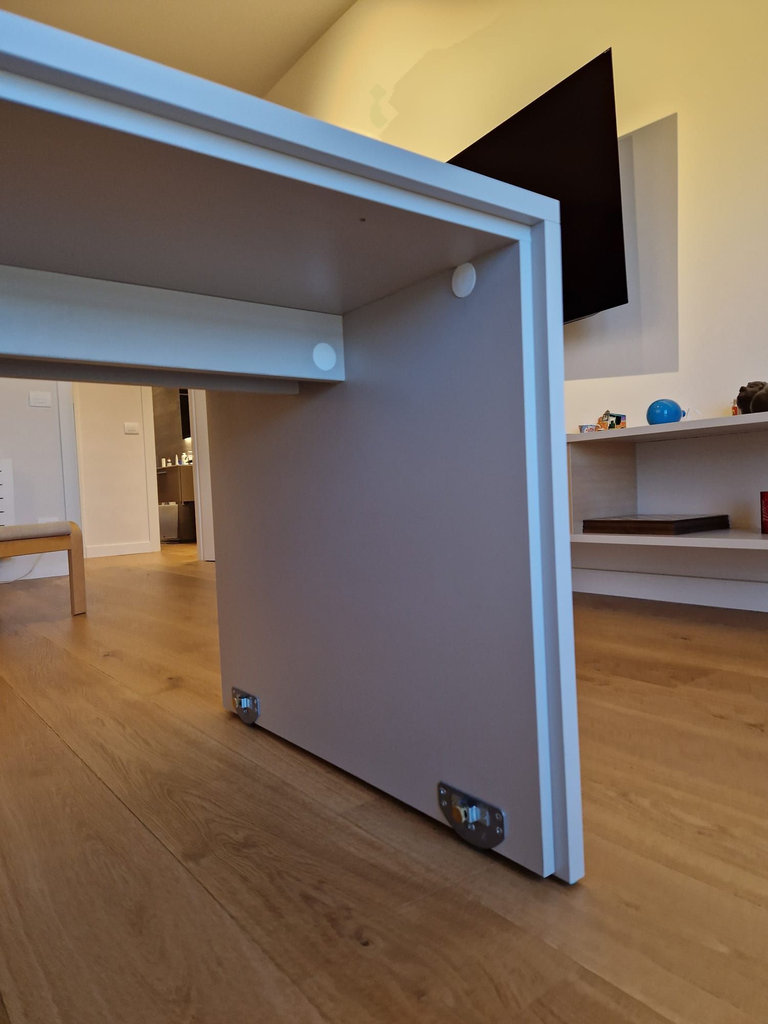 Un tavolo bianco in un soggiorno con una tv sul muro