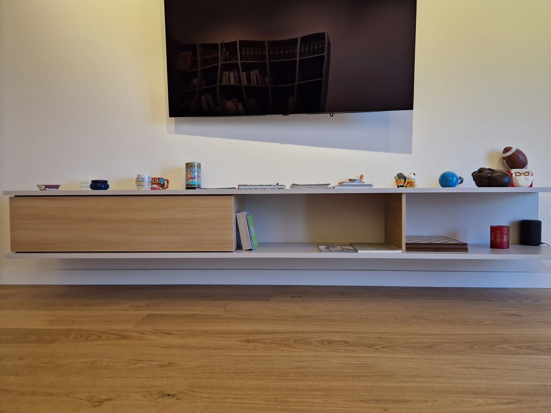 Un soggiorno con una mensola e una tv a schermo piatto
