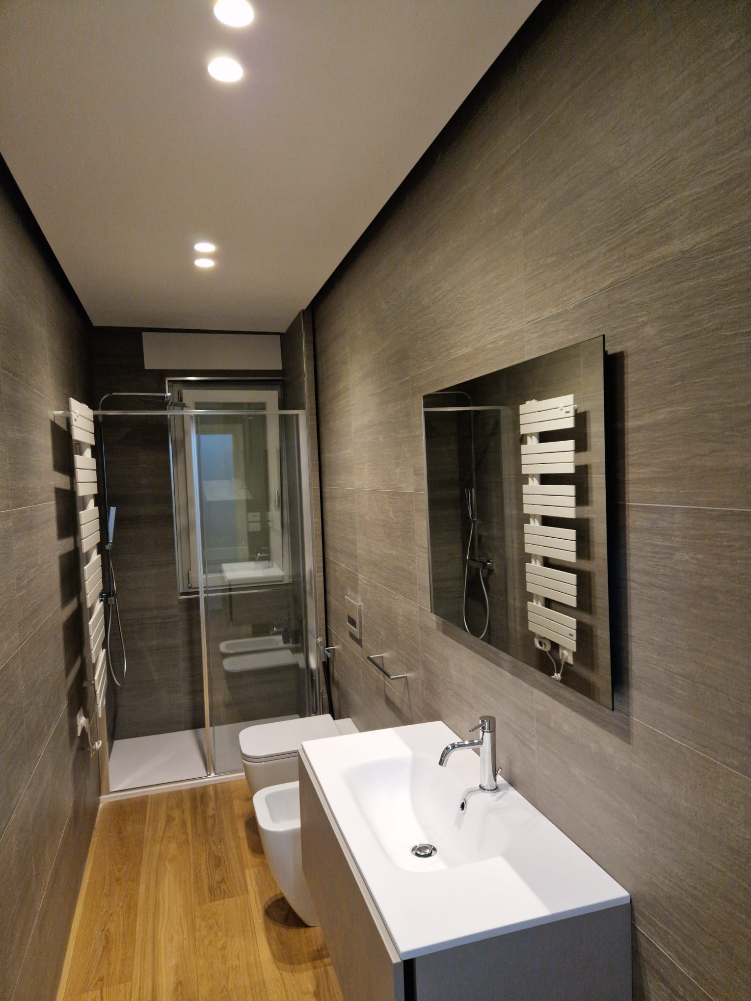 Un bagno con un lavandino, un water e uno specchio