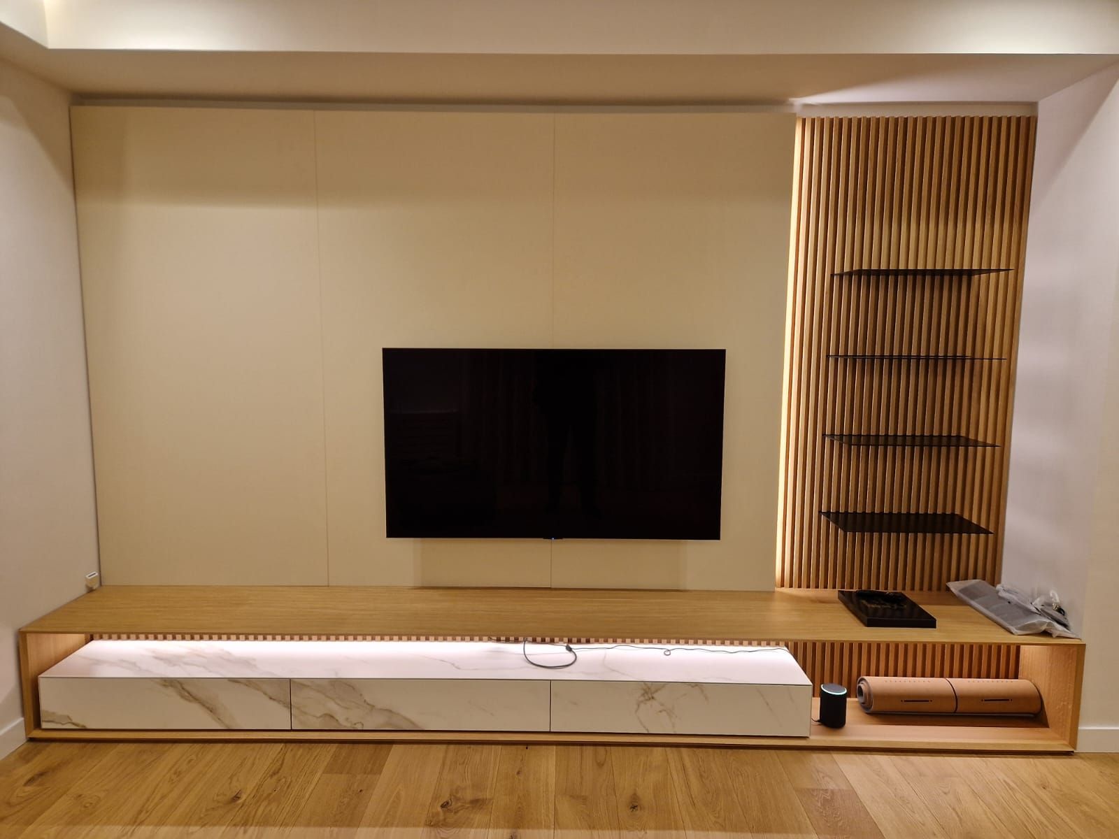 Un soggiorno con una tv a schermo piatto sul muro