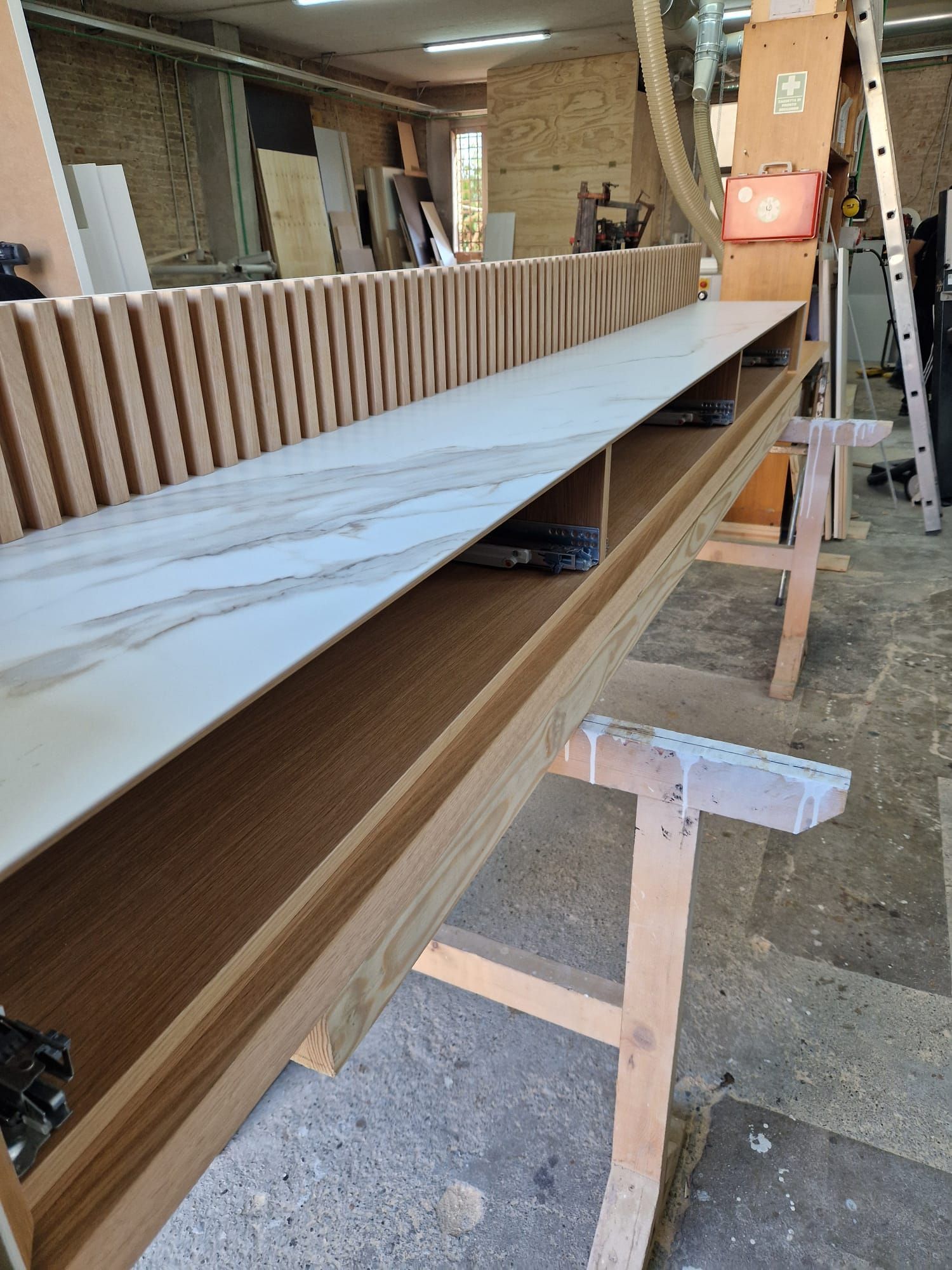 Un grande pezzo di legno è appoggiato su un tavolo di legno in un'officina.