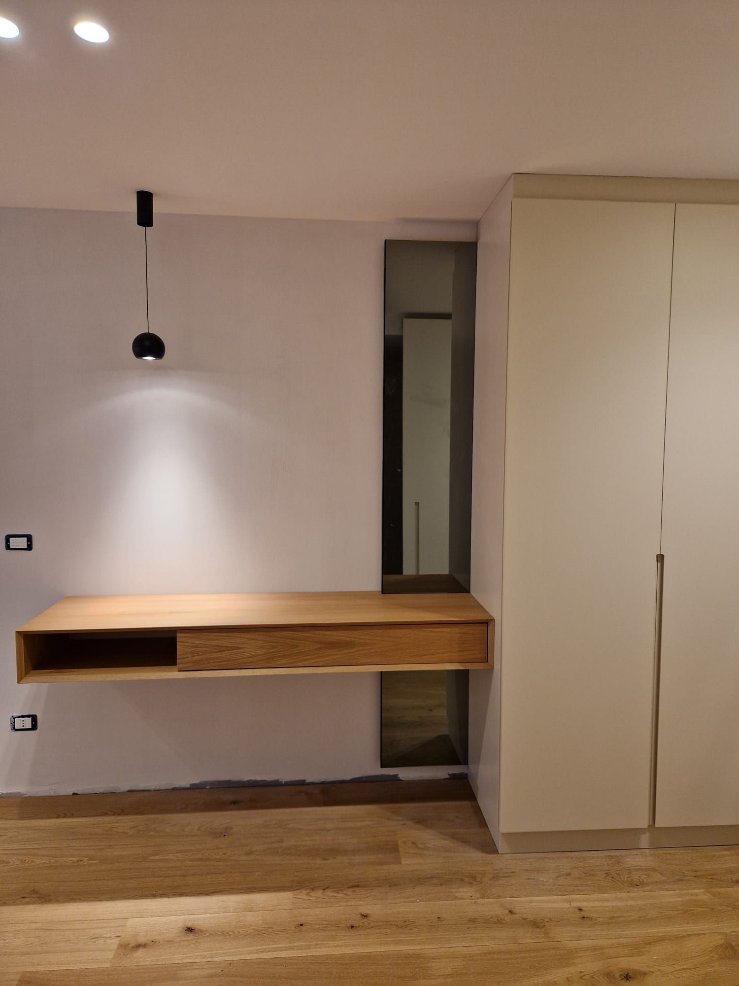 C'è una scrivania di legno al centro della stanza.