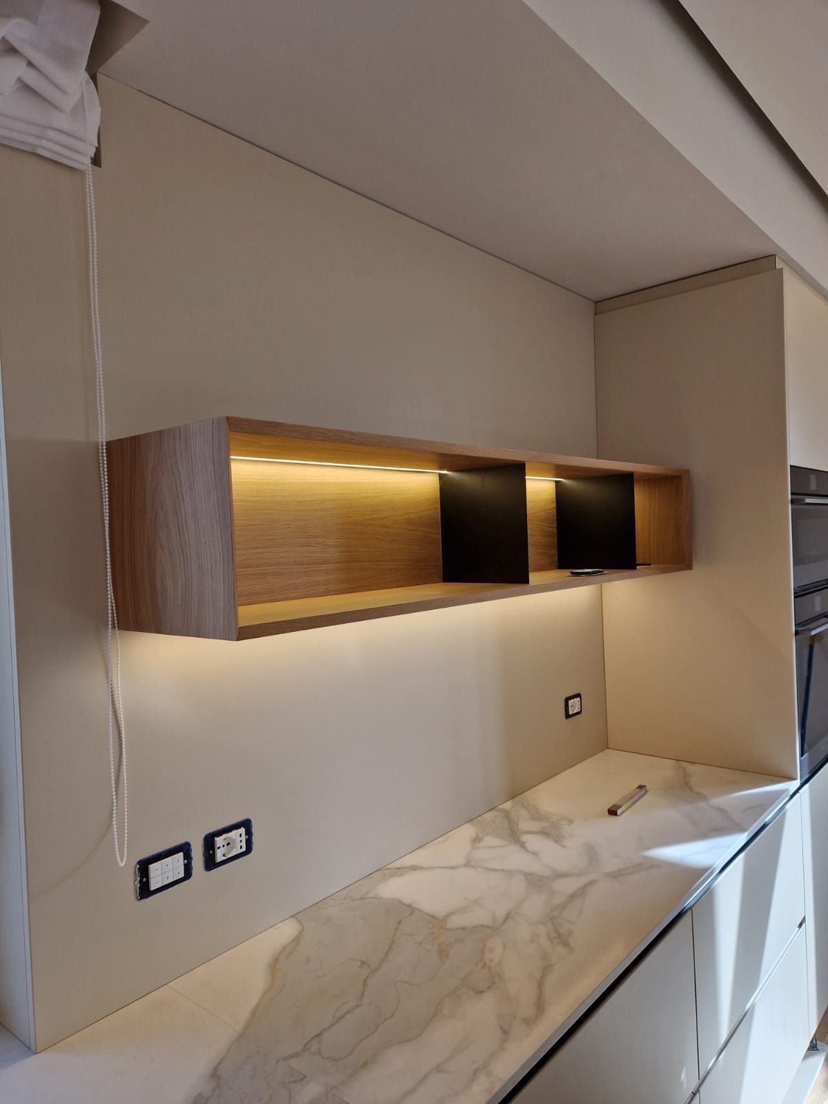 Una cucina con mobili bianchi e un piano di lavoro in marmo