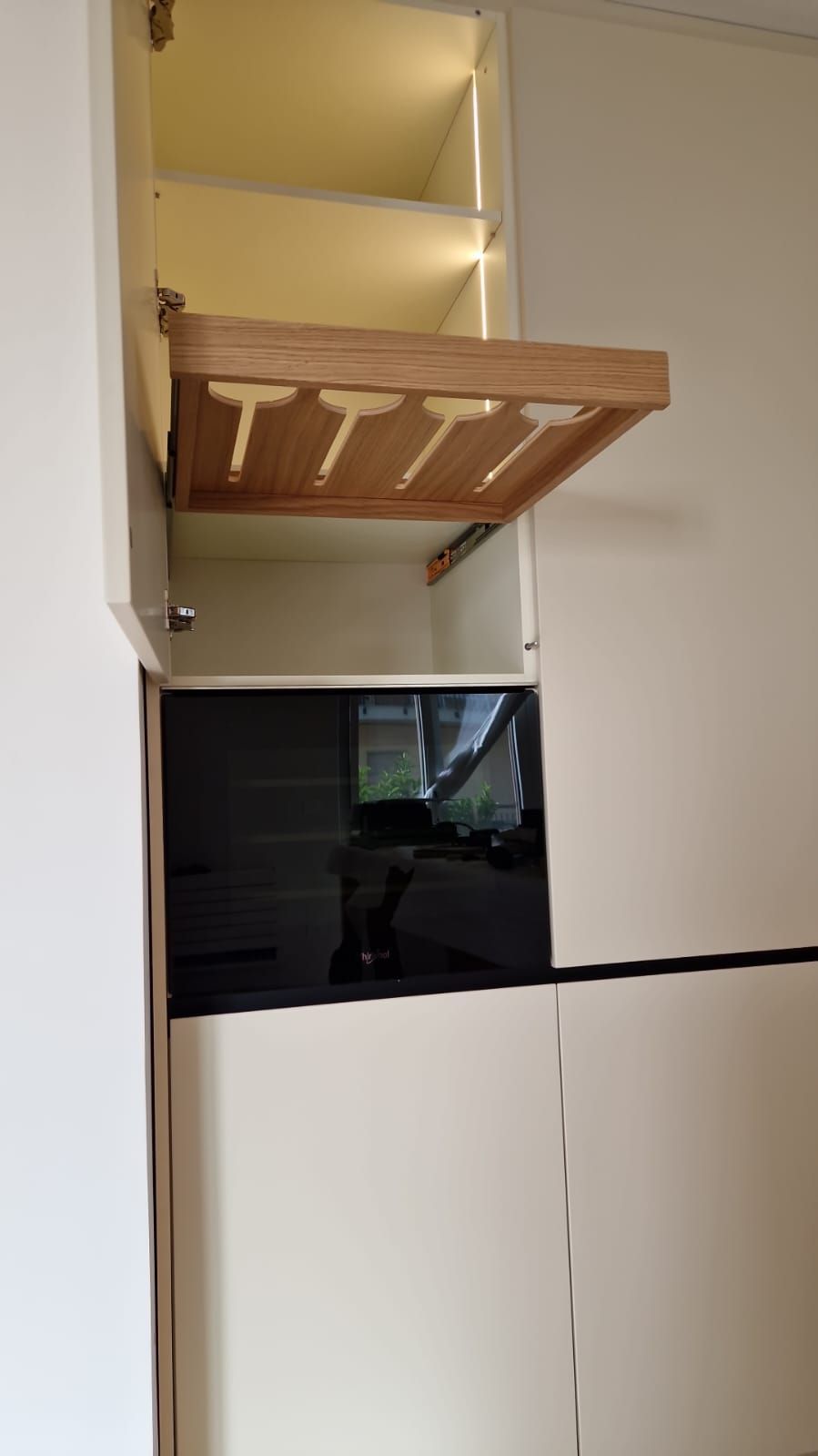 Un mobile bianco con un ripiano in legno aperto.