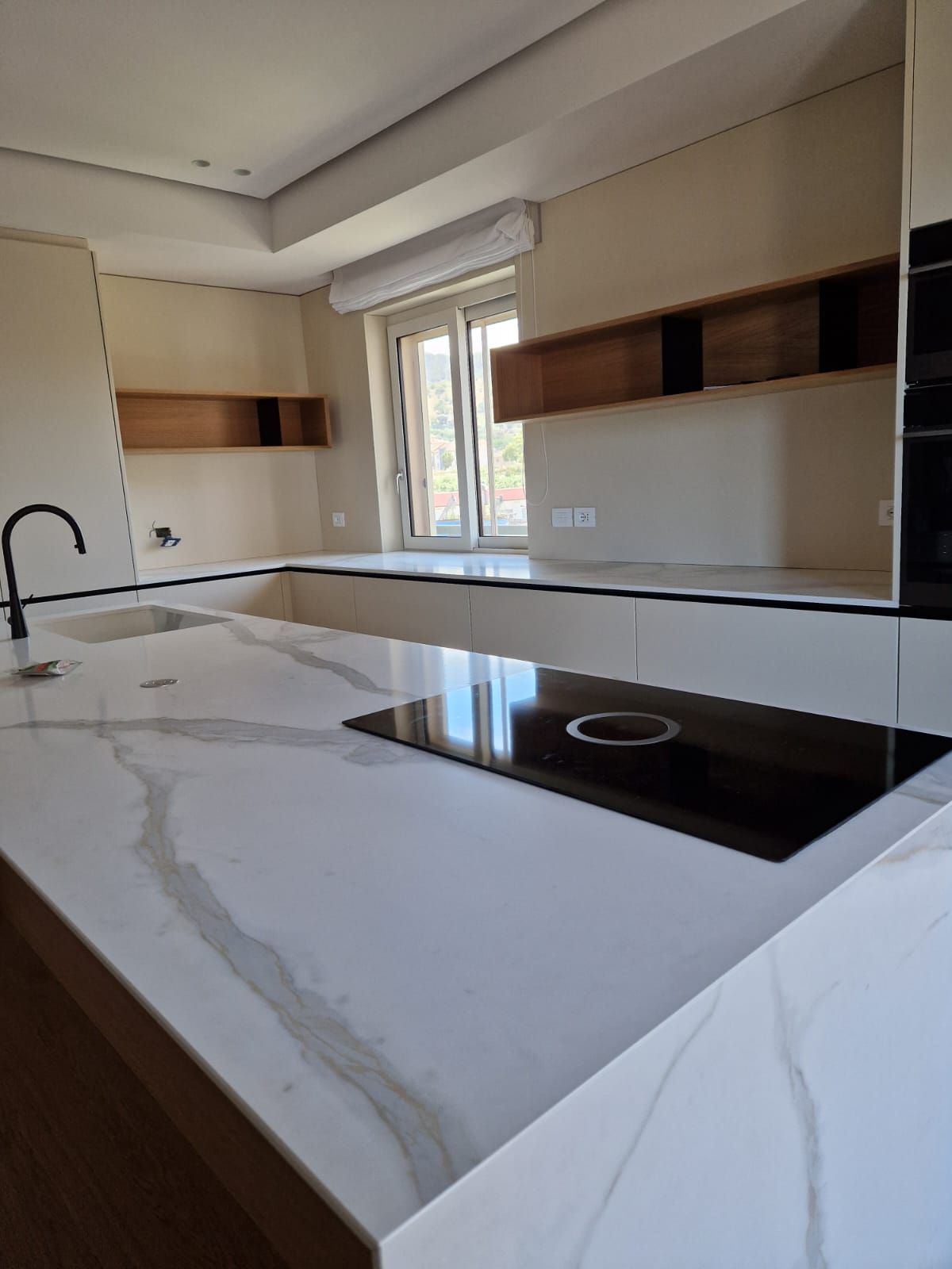 Una cucina con piano cottura, forno e lavello.