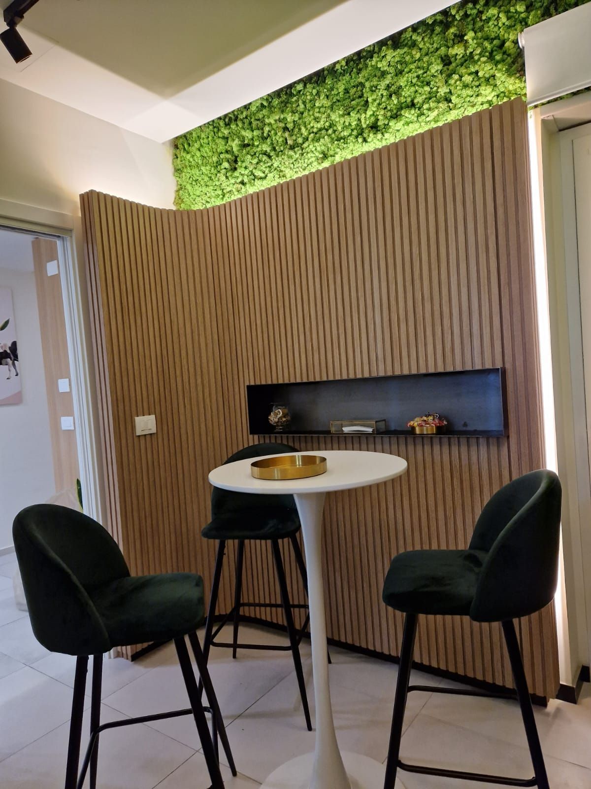 Una stanza con un tavolo e delle sedie e una parete verde