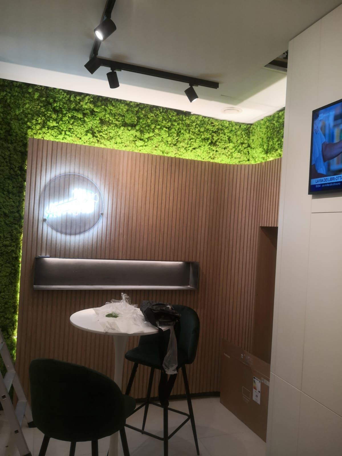 Una stanza con un tavolo e delle sedie e una tv sul muro