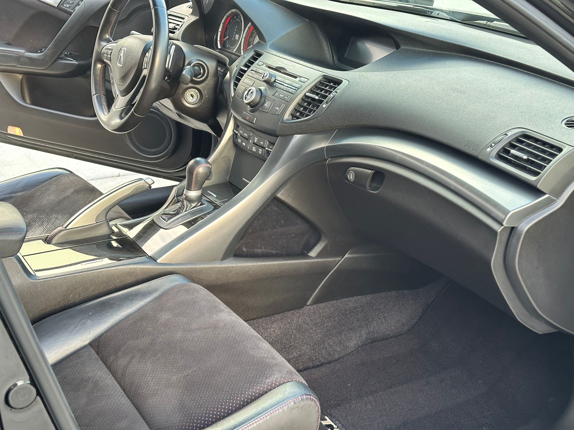 Black interior of a car with leather seats, steering wheel, dashboard, and center console visible.