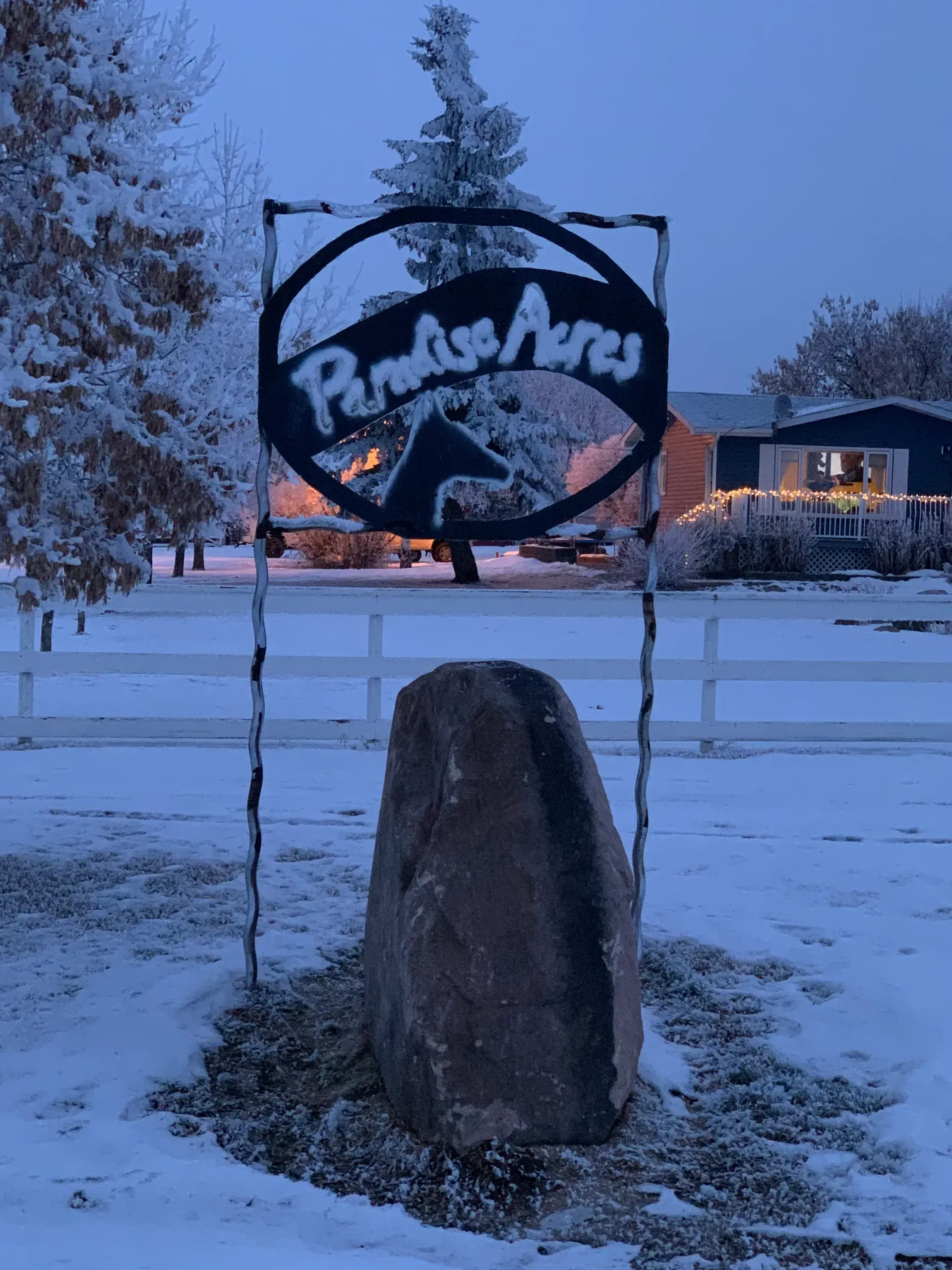 A sign for paradise acres is in the snow