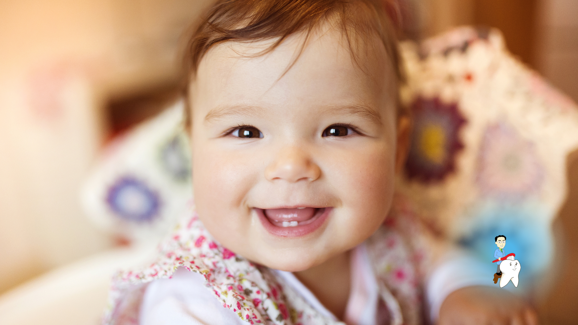 A baby girl is smiling for the camera while sitting on a bed.