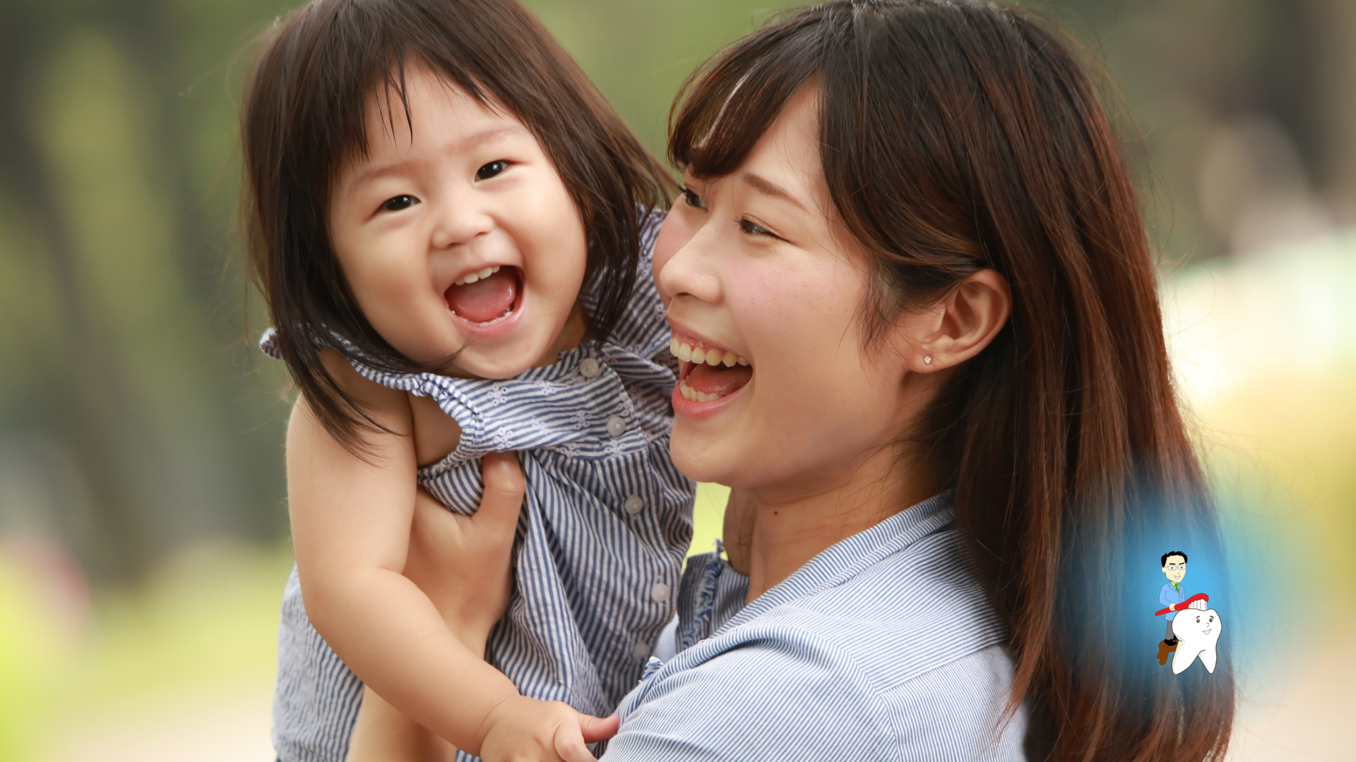 Woman holding and laughing with a child in an outdoor setting.