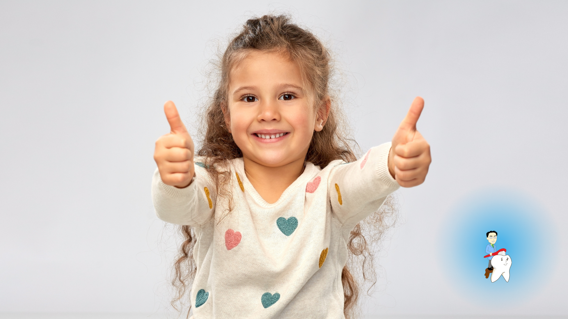 Smiling child with curly hair giving two thumbs up.