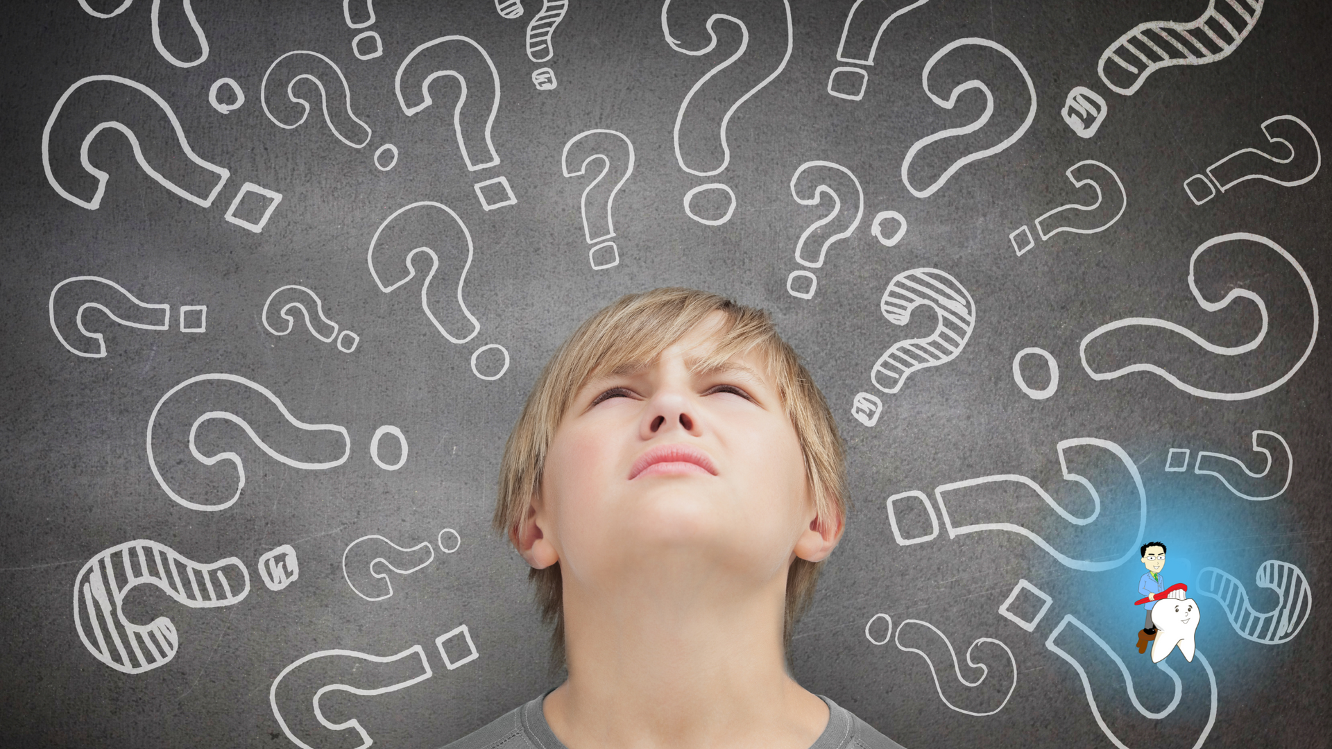 A young boy is looking up at a chalkboard with question marks drawn on it.